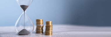 Masada bozuk paralar olan kum saati.