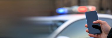 Polis arabasıyla telefon eden adam.