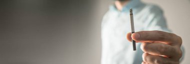 Sigara içen genç bir adam. Sigara dumanı yayılmış.