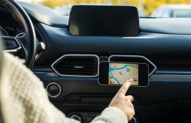 Arabada telefon rehberi kullanan bir kadın sürücü.,