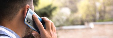 Genç adam akıllı telefonlardan konuşuyor.