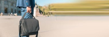 İşadamı siyah çantayı stree içinde tutuyor.