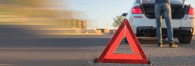 Trafik uyarısı yolda. Araba ve şoför arkada.