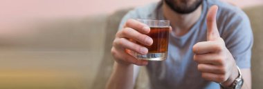 Elinde bir bardak alkol olan bir adam.