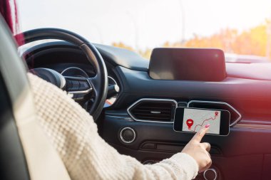 Arabada telefon rehberi kullanan bir kadın sürücü.,