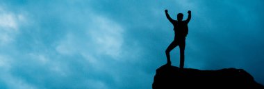 Başarı: Erkek gün batımı silueti kollarını kaldırarak kutluyor.