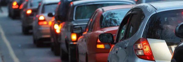 Bulanık yoğun yol, trafik ışıklarında bekleyen uzun arabalar.