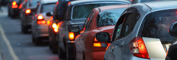 Blurred busy road long line of cars waiting at stop light