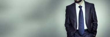 İşadamı elleri ceplerinde duruyor.