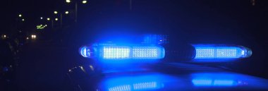 Polis gece mavi siren göstericisiyle arabada.