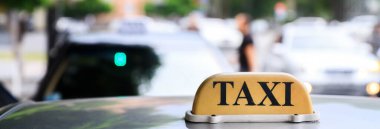 Arabadaki sarı taksi tabelası.