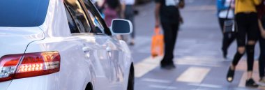 Beyaz araba pedastrianların karşıya geçmesini bekliyor.. 