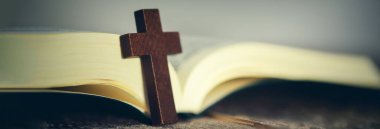 Ahşap masanın arkasında İncil 'i çapraz yap.