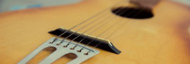 Akustik gitar yakın çekim. Klasik akustik gitarın altı teli.