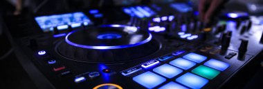 Profesyonel DJ ve pikabını çalan kişi gece sahnesinde.