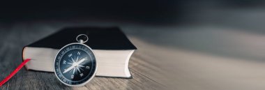 Kitap ve pusula masanın üstünde. Dünyanın konsept yönü