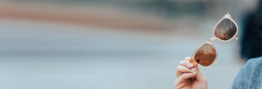 Han 'ında güneş gözlüğü tutan kadın.