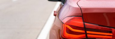 Kırmızı araba yolda, arka tarafta.