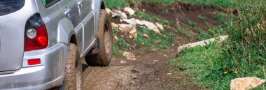 Araba dağdaki çamurun içinden geçiyor.