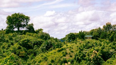 Aerial view of beautiful mountain landscape in the hills of Bandarban, Bangladesh. Zoom houses are visible in the distance. Photo taken from Meghla, Bandarban, Chittagong, Bangladesh.