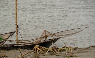 Gorai-Madhumati River. Fishing boat in the river. Fishermen are fixing the fishing nets on the boat. clipart