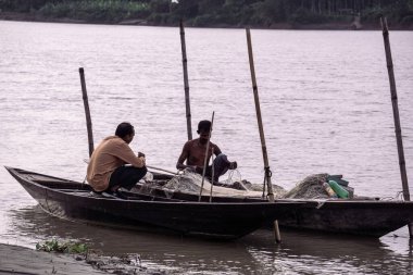 Gorai-Madhumati River. Fishing boat in the river. Fisherman is fixing the fishing net on the boat. The scene was captured on 24 October 2023 from Rajbari, Bangladesh. clipart