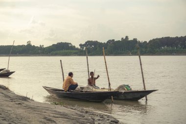 Gorai-Madhumati River. Fishing boat in the river. Fisherman is fixing the fishing net on the boat. The scene was captured on 24 October 2023 from Rajbari, Bangladesh. clipart