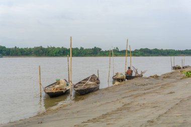 Bangladeş 'in Gorai-Madhumati nehri. Nehir doğası sahnesinde balıkçı teknesi. Balıkçı ağı tamir ediyor. Sahne 24 Ekim 2023 tarihinde Rajbari, Bangladeş 'te çekildi..