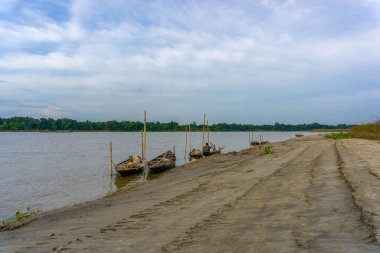 Gorai-Madhumati Nehri. Nehirde bir balıkçı teknesi. Bir balıkçı teknedeki balık ağını tamir ediyor. Sahne 24 Ekim 2023 tarihinde Rajbari, Bangladeş 'te çekildi..
