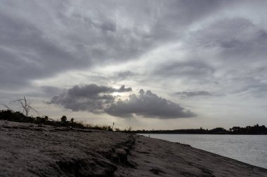 Gorai-Madhumati river of Bangladesh. Evening on the river. Fishing boats are tied on the river bank. The river flows under the twilight sky. clipart