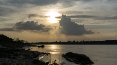 Bangladeş 'in Gorai-Madhumati nehri. Nehirde akşam yemeği. Balıkçı tekneleri nehir kıyısında bağlı. Nehir alacakaranlık gökyüzünün altından akar..