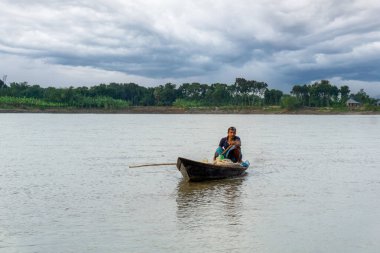 Gorai-Madhumati river of Bangladesh. Evening by the river. Fishermen are fishing in boats in the middle of the river. The river flows under the twilight sky. clipart