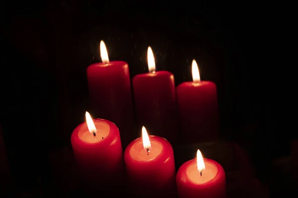 在黑暗中点燃红色的蜡烛 — 图库照片