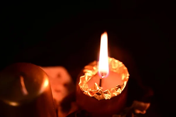 金色的蜡烛在黑暗的背景上燃烧 — 图库照片#