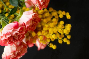 beautiful  composition   with roses and mimosas    on black background