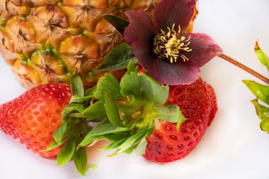 Ananas, taze çilek ve çiçek.