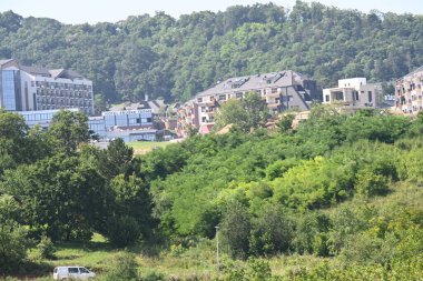 Yeşil dağları olan şehir mimarisi manzarası