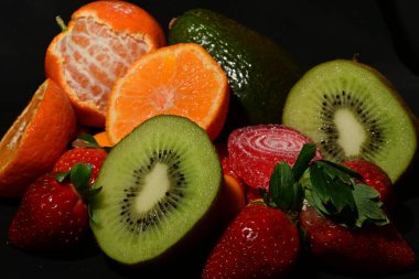 Siyah arka planda sarılmış jöleli bir grup meyve.