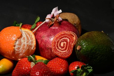 Siyah bir yüzey üzerinde çeşitli meyve ve sebzeler