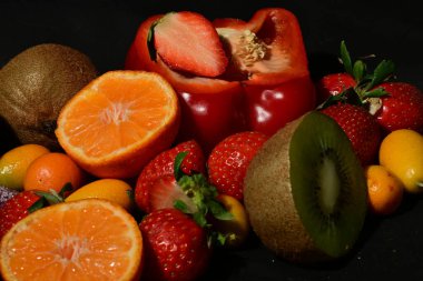 Siyah arka planda rulo jöleli meyve ve sebze çeşitleri.