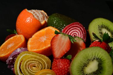 Siyah arka planda sarılmış jöleli meyve ve sebze çeşitleri