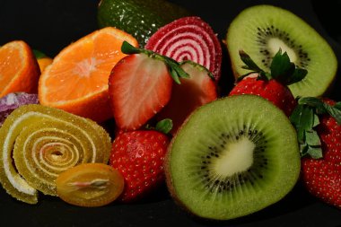 Siyah arka planda sarılmış jöleli meyve ve sebze çeşitleri