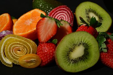 Siyah arka planda sarılmış jöleli meyve ve sebze çeşitleri