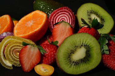 Siyah arka planda sarılmış jöleli meyve ve sebze çeşitleri