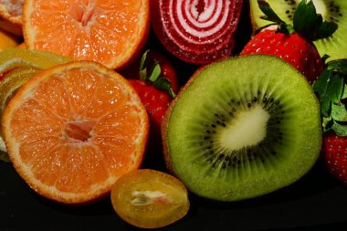 Siyah arka planda sarılmış jöleli meyve ve sebze çeşitleri