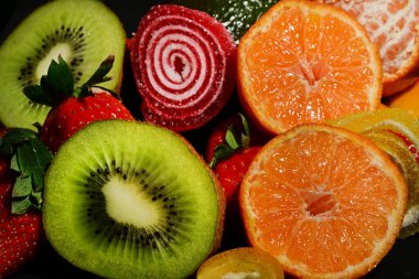 Siyah arka planda sarılmış jöleli meyve ve sebze çeşitleri