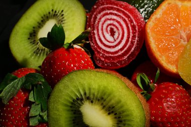 Siyah arka planda sarılmış jöleli meyve ve sebze çeşitleri