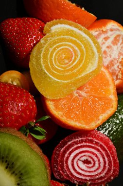 Siyah arka planda sarılmış jöleli meyve ve sebze çeşitleri