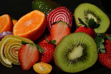 Siyah arka planda sarılmış jöleli meyve ve sebze çeşitleri