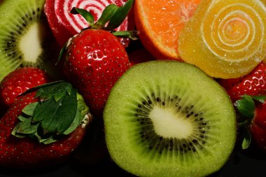 Siyah arka planda sarılmış jöleli meyve ve sebze çeşitleri